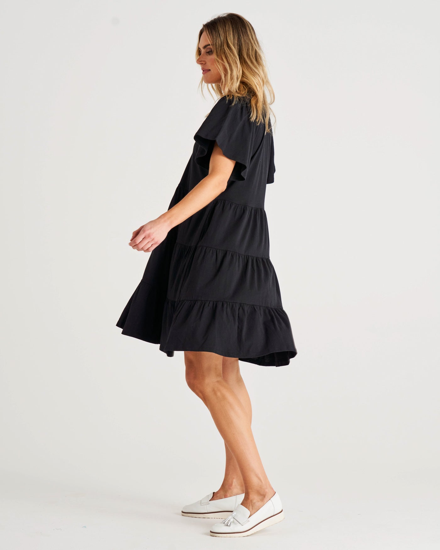 Cressida Dress - Black | Betty Basics | Introducing the Cressida Dress your carefree chic essential! With a V-neck, flutter sleeves, a relaxed tiered body, and pockets for added flair, this dress effortles