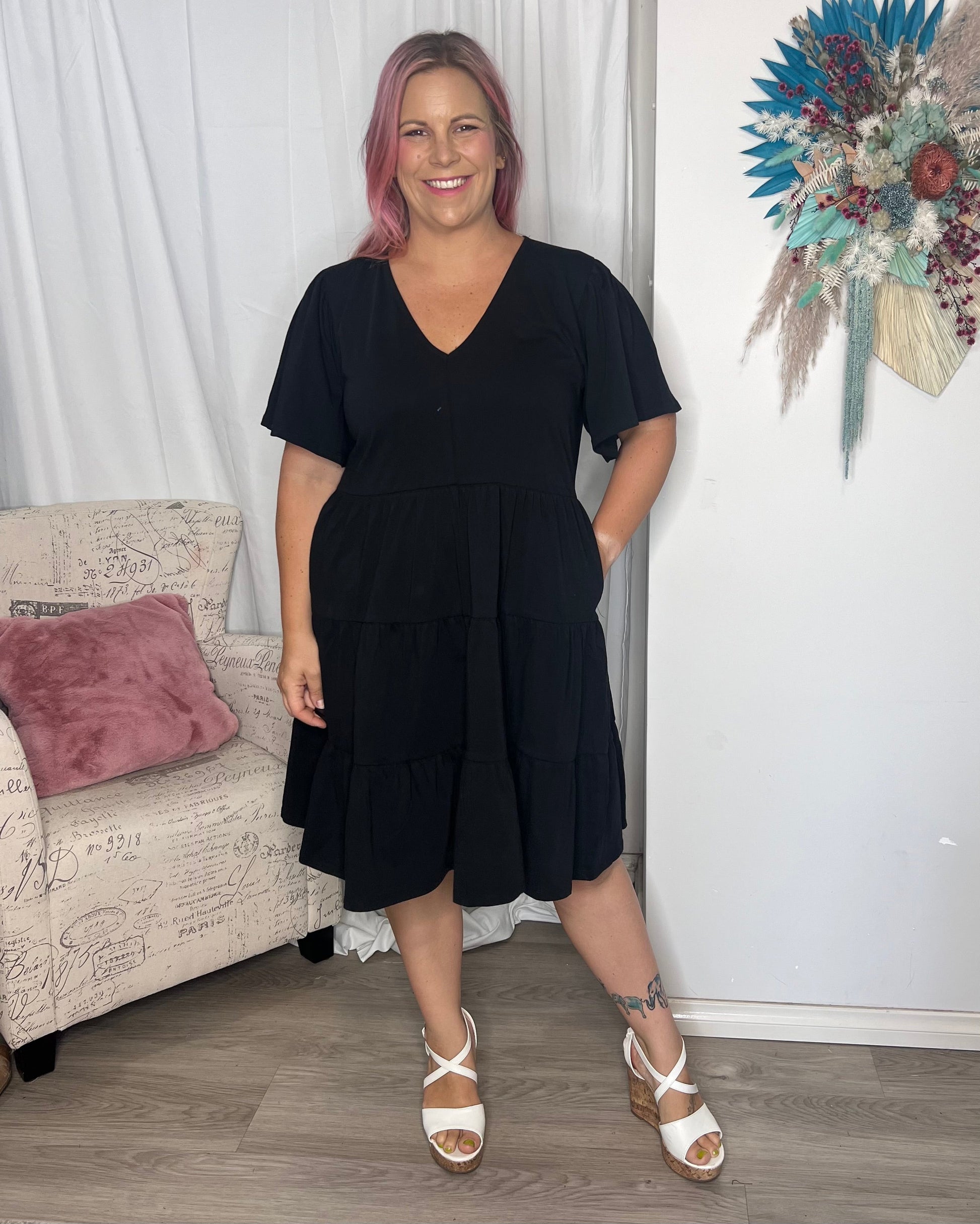 Cressida Dress - Black | Betty Basics | Introducing the Cressida Dress your carefree chic essential! With a V-neck, flutter sleeves, a relaxed tiered body, and pockets for added flair, this dress effortles