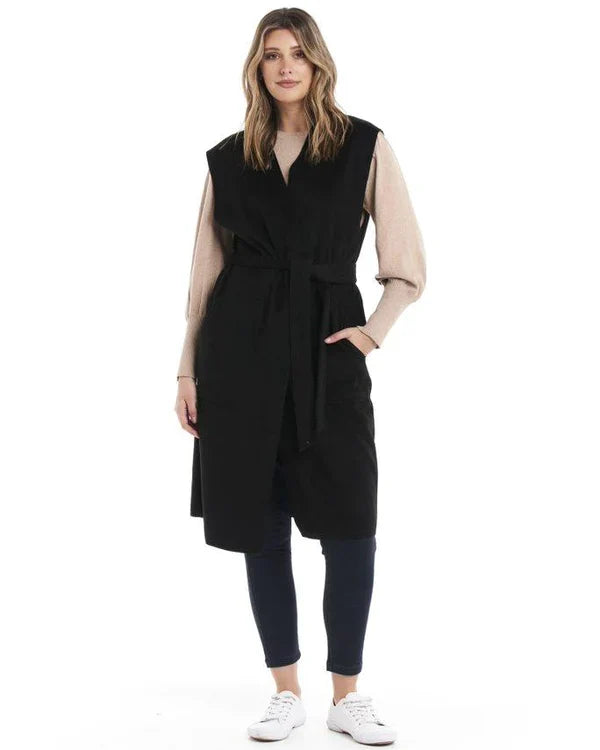 Alica Belted Sleeveless Coat - Black | Betty Basics | Are you ready to add a touch of elegance to your autumnal layering game? Look no further than the Alicia Belted Sleeveless Coat! This piece is the perfect combinatio