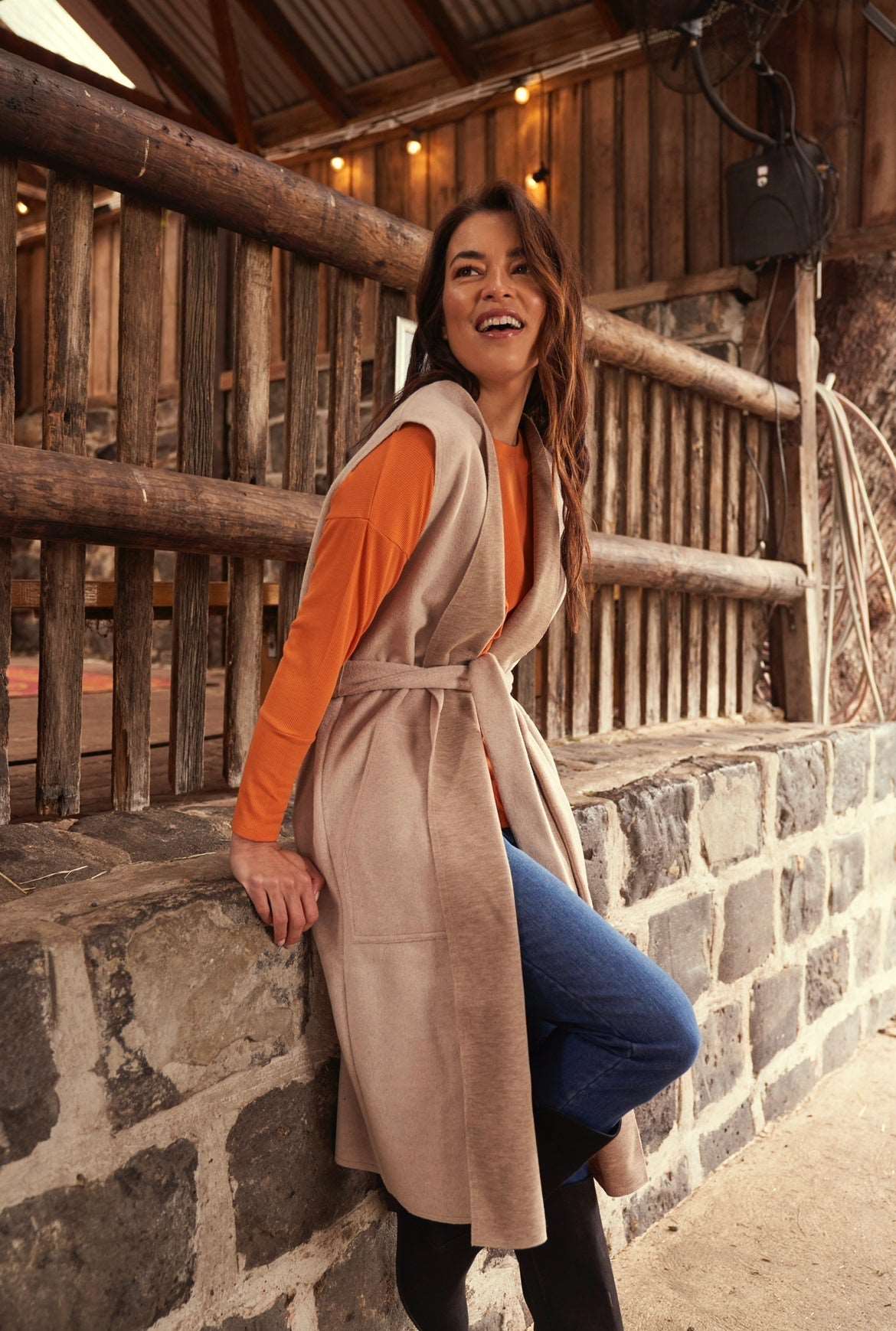 Alica Belted Sleeveless Coat - Beige | Betty Basics | Are you ready to add a touch of elegance to your autumnal layering game? Look no further than the Alicia Belted Sleeveless Coat! This piece is the perfect combinatio