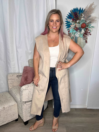 Alica Belted Sleeveless Coat - Beige | Betty Basics | Are you ready to add a touch of elegance to your autumnal layering game? Look no further than the Alicia Belted Sleeveless Coat! This piece is the perfect combinatio