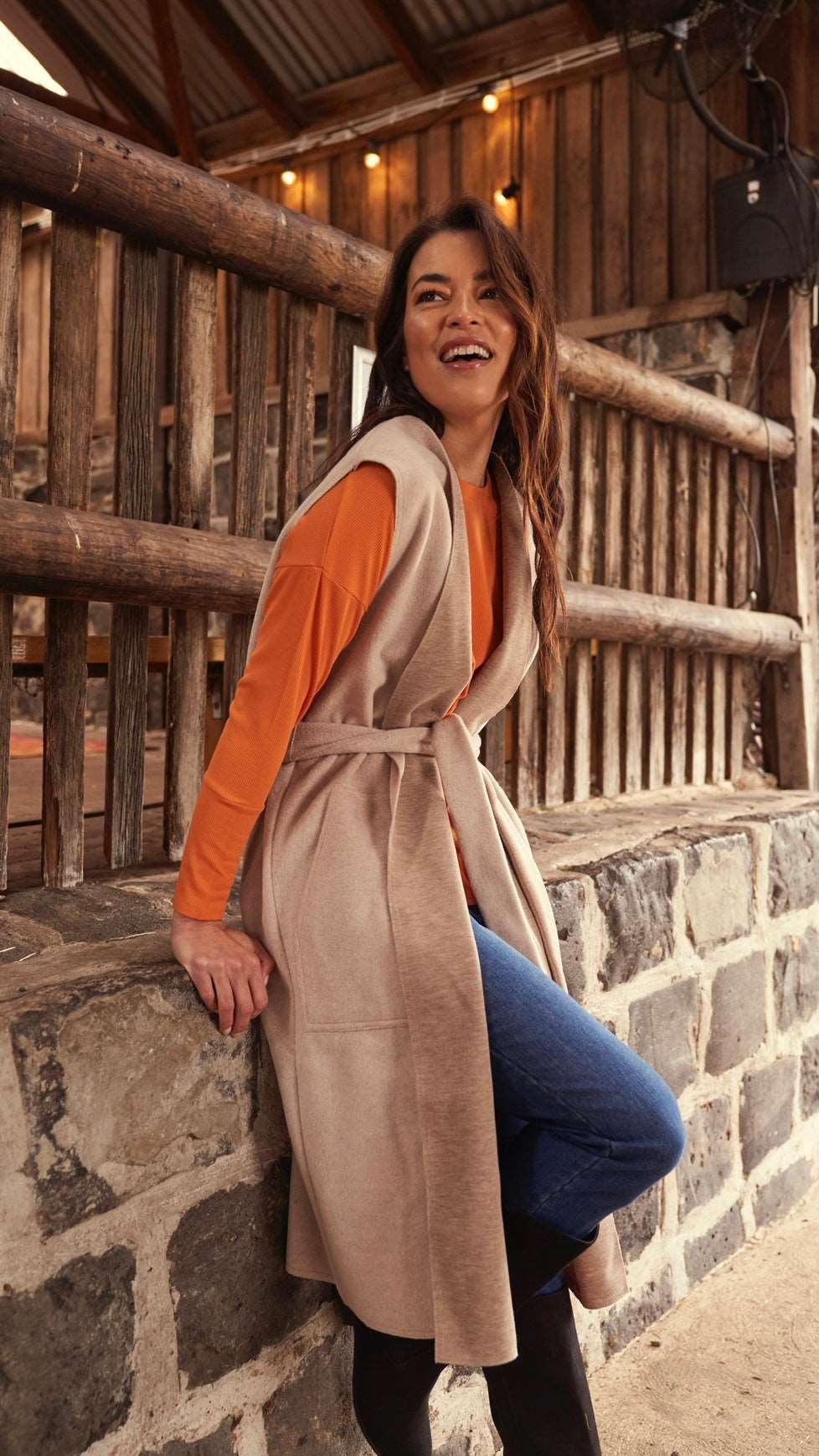 Alica Belted Sleeveless Coat - Beige | Betty Basics | Are you ready to add a touch of elegance to your autumnal layering game? Look no further than the Alicia Belted Sleeveless Coat! This piece is the perfect combinatio