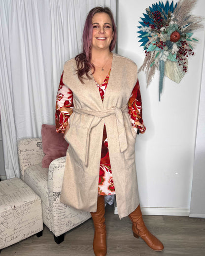 Alica Belted Sleeveless Coat - Beige | Betty Basics | Are you ready to add a touch of elegance to your autumnal layering game? Look no further than the Alicia Belted Sleeveless Coat! This piece is the perfect combinatio