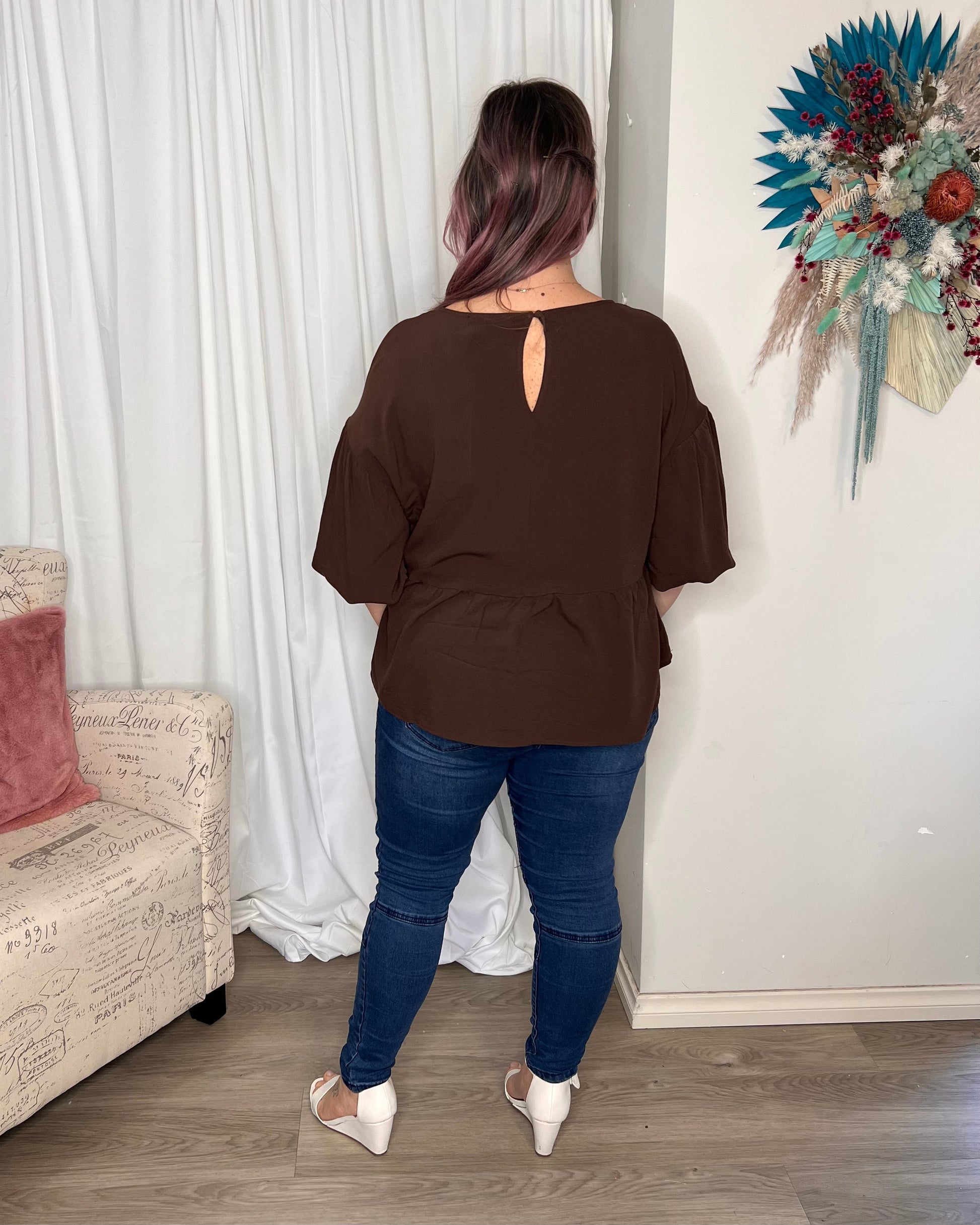 Yasmin Bubble Sleeve Top - Brown | Sass Clothing |  
With its trendy V-neckline and dropped shoulder into bubble sleeves, this top exudes effortless style. The relaxed fit offers ultimate comfort, while the back keyh