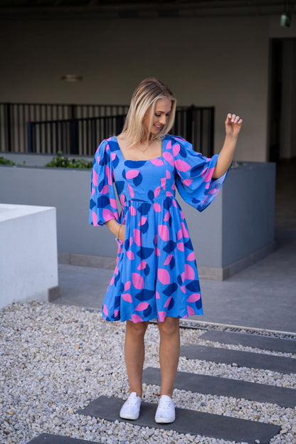 Amora Flute Sleeve Dress: The Amora Dress features a super cute pink and blue spotted design. It has gorgeous fluted sleeves and POCKETS
Features:

Shirred back
Mid length fluted sleeves
Pock - Ciao Bella Dresses 