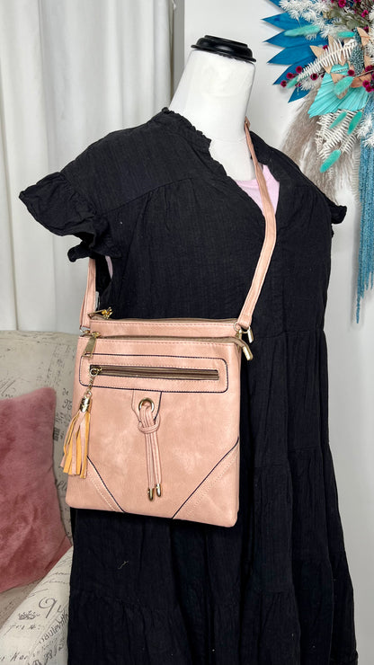Crossbody Bag - Medium Tassel - Blush: A spot for everything! This bag has pockets everywhere
Features:

3 functional zip pouches
1 open pouch compartment
Tassel features
Removable, adjustable crossbody s - Ciao Bella Dresses